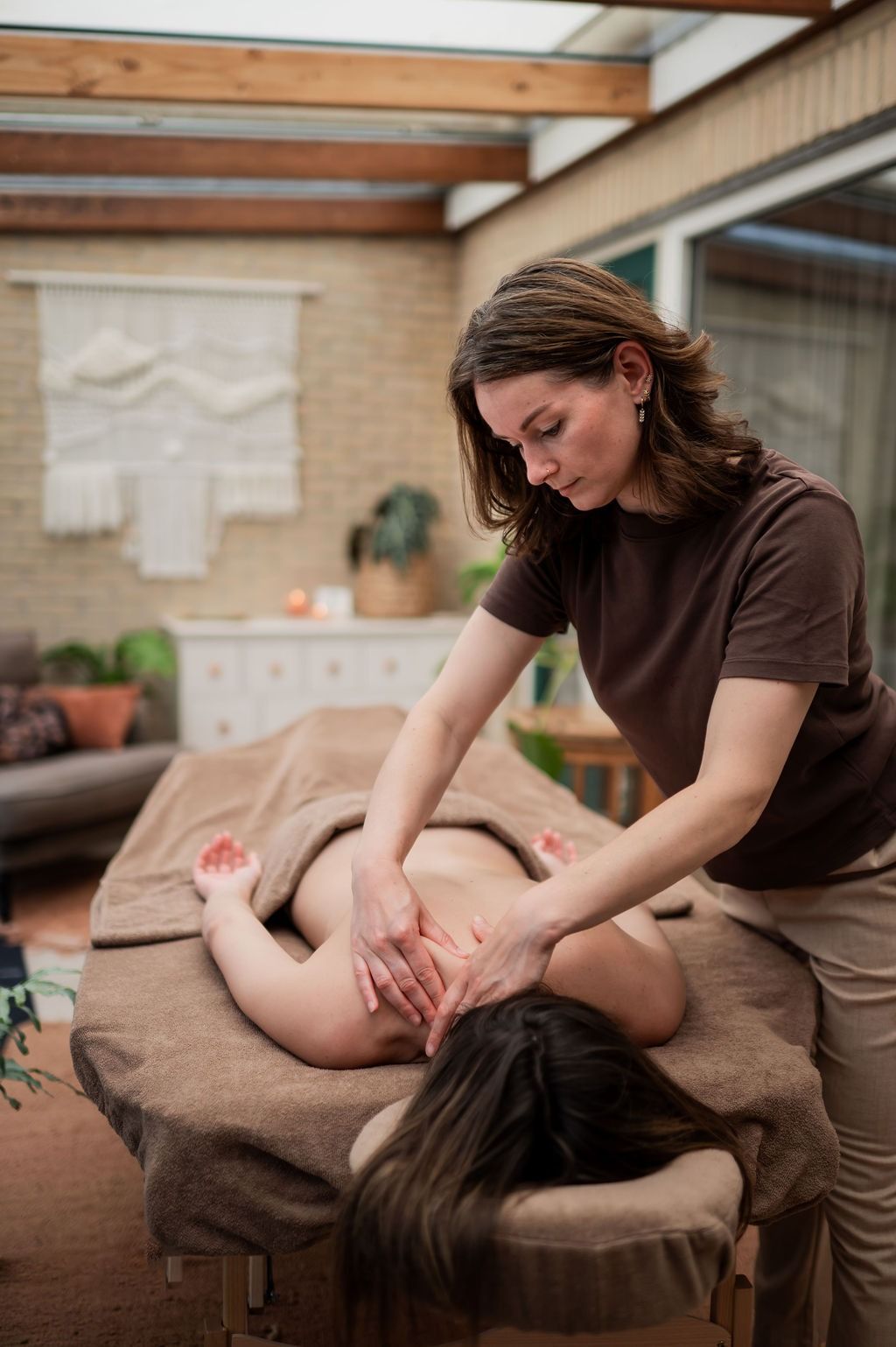 Quirina geeft een rugmassage in de behandelruimte van Menyentuh